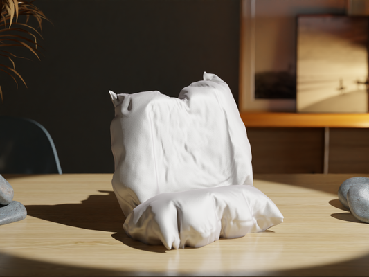 White ceramic sculpture of a cat on a wooden table with a blurred background