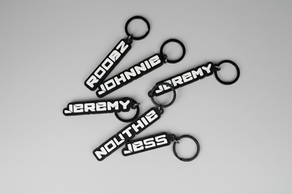 Black keychains with white text on a gray background