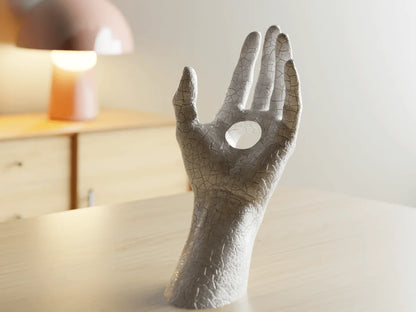 Decorative sculpture of a hand with a fork on a surface
