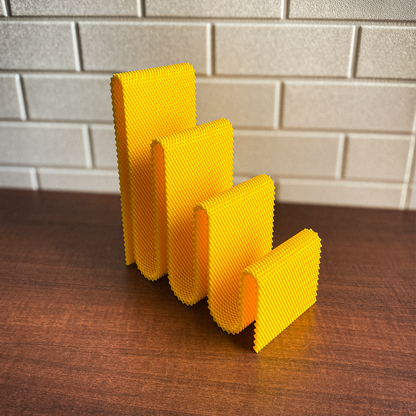 Set of yellow sponges on a wooden surface with a tiled wall background