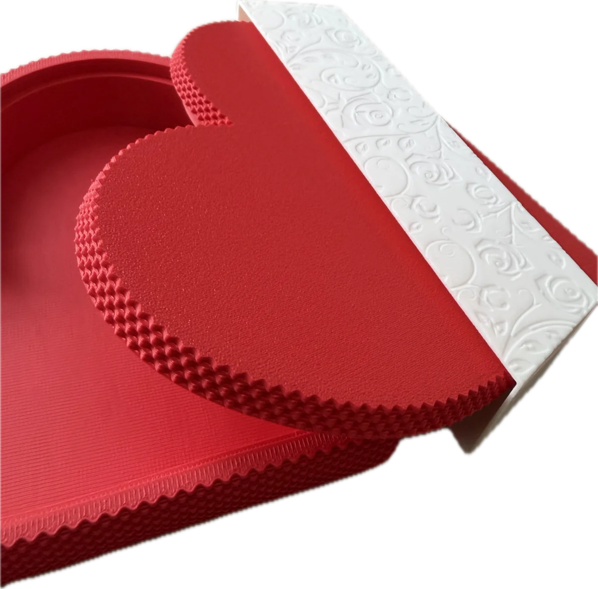 Red textured mat with embossed pattern on a white background