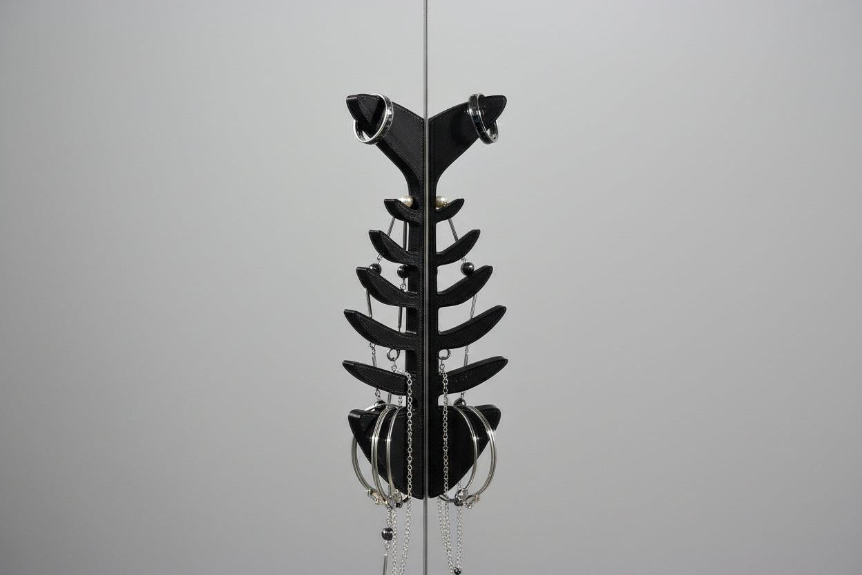 Black metal sculpture resembling a fish on a gray background
