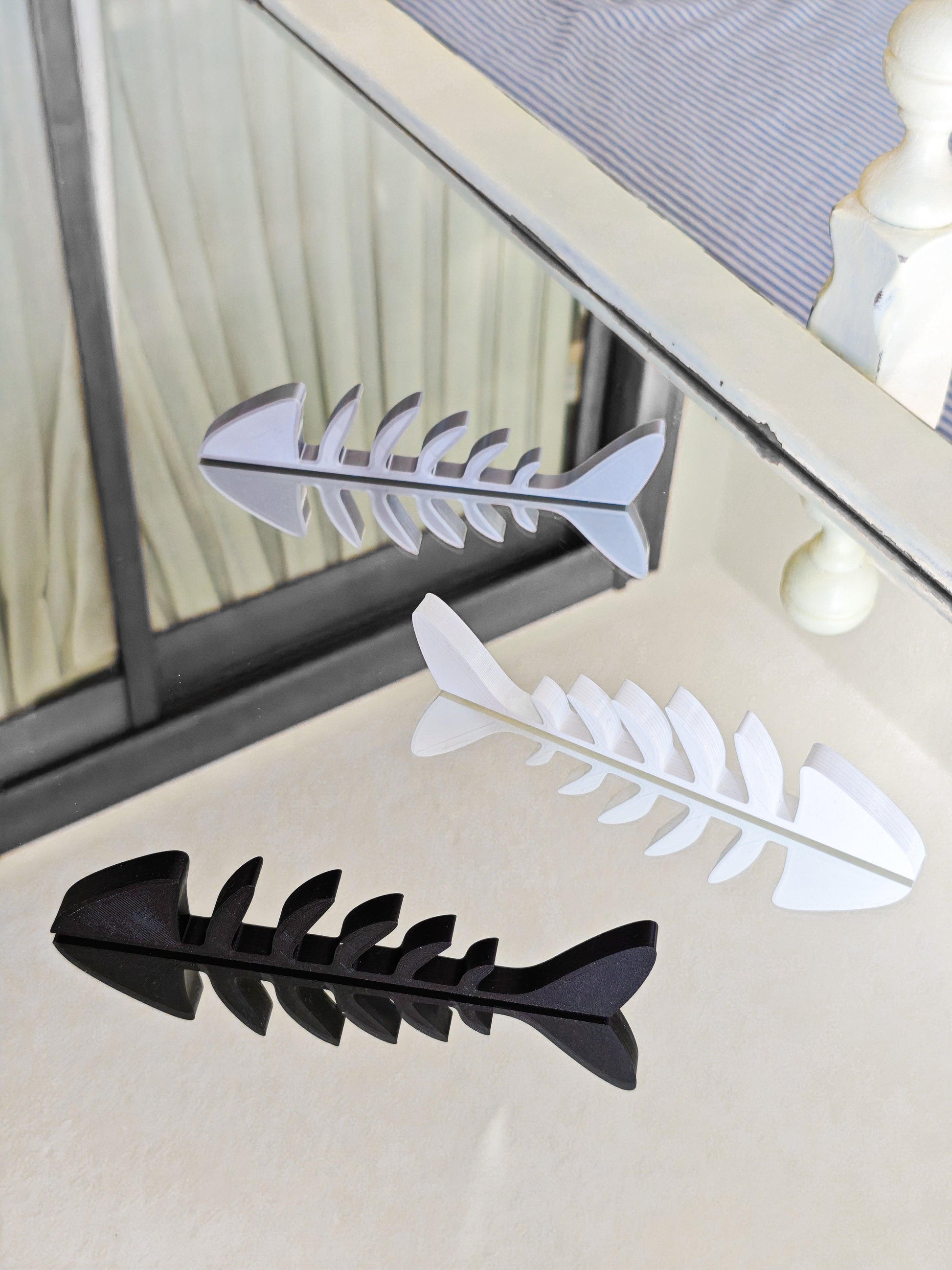 Black and white fishbone designs on a glass surface with a blurred background