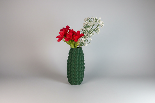 Green textured vase with red flowers and white baby's breath on a light gray background