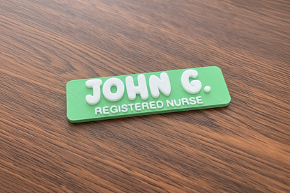 Green name tag with 'JOHN G. REGISTERED NURSE' on a wooden surface
