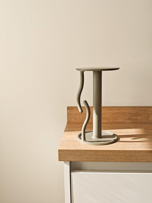 Ceramic candle holder on a wooden surface with a plain background