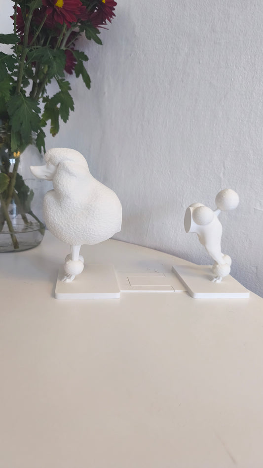 White plastic poodle bookend on a stand with a neutral background
