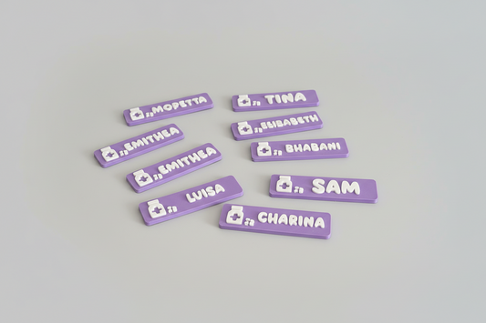 Purple name tags with names printed on them on a gray background