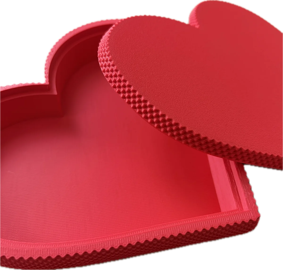 Red heart-shaped object with textured surface on a white background