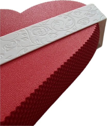 Red textured object with a white embossed band on a white background