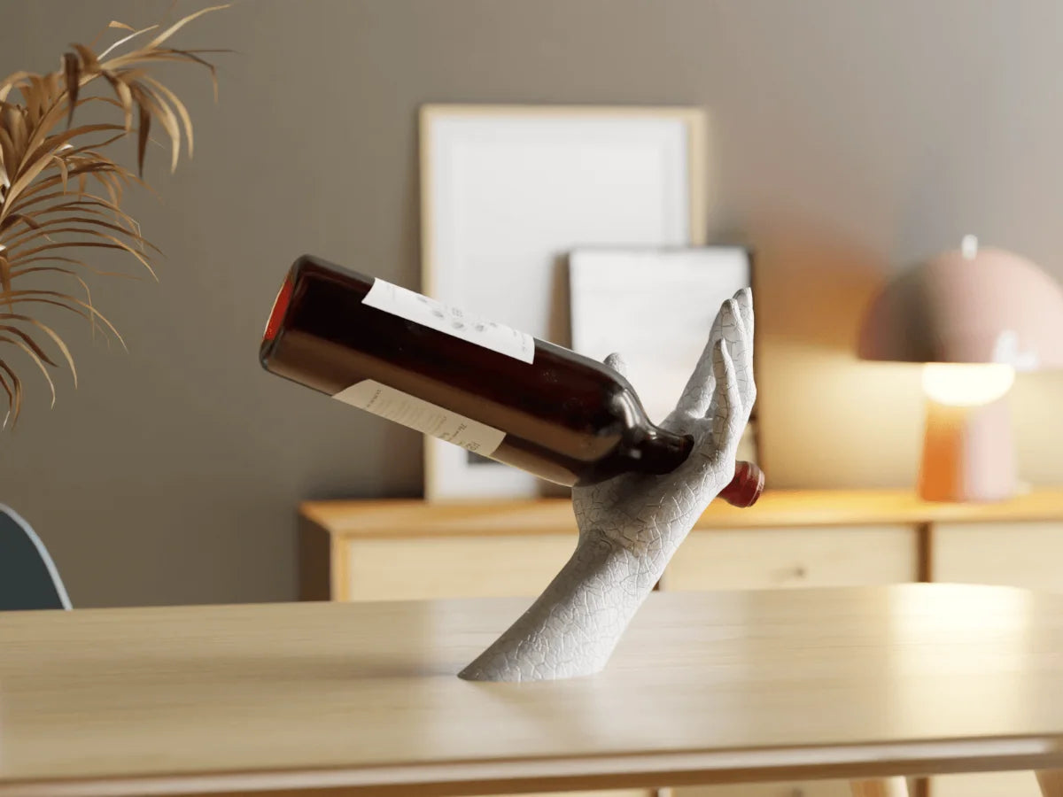 Wine bottle held by a decorative arm on a table with a blurred background